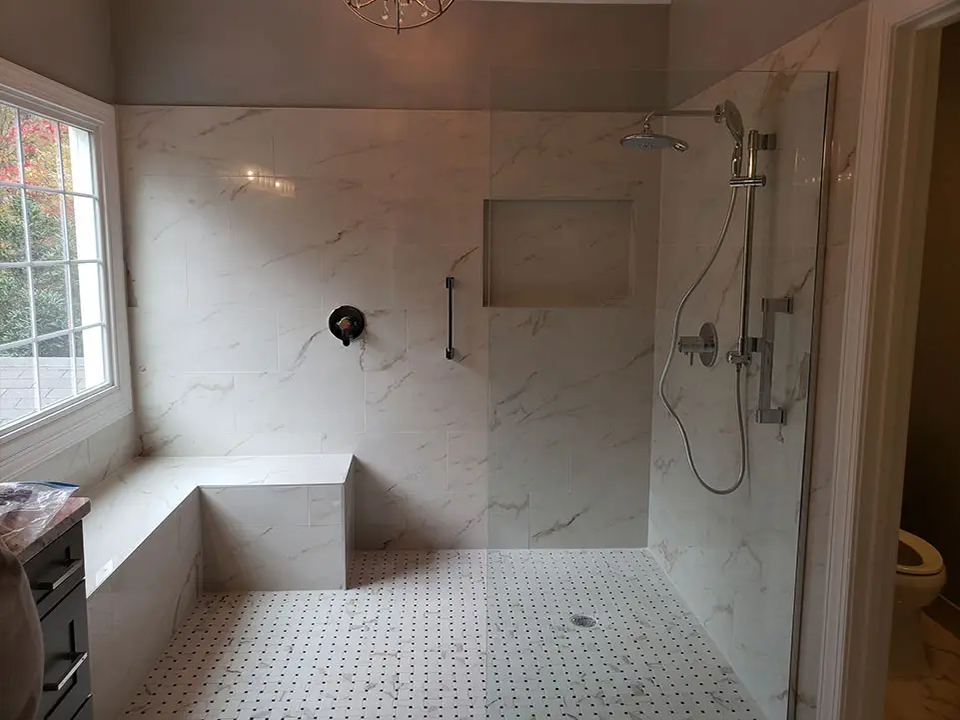 Completed bathroom remodel with a tiled walk-in shower and a double vanity