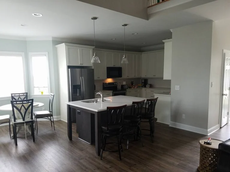 Remodeled kitchen with white cabinetry, a large island and pendant lighting